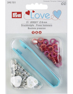 Doos met 21 drukknopen in rood, koraal en fuchsia met 8 mm gereedschap.
